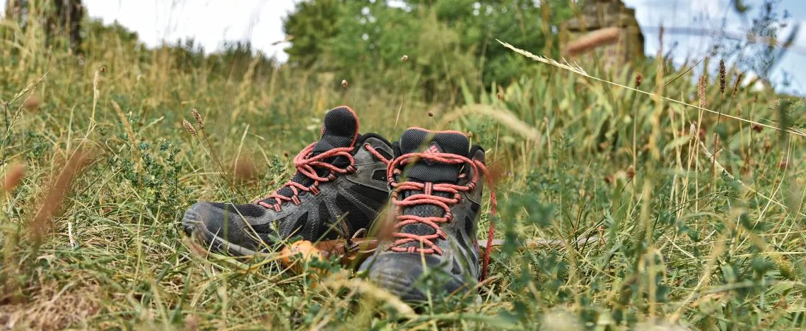 Pilgerschuhe und -stab am Kreuzweg